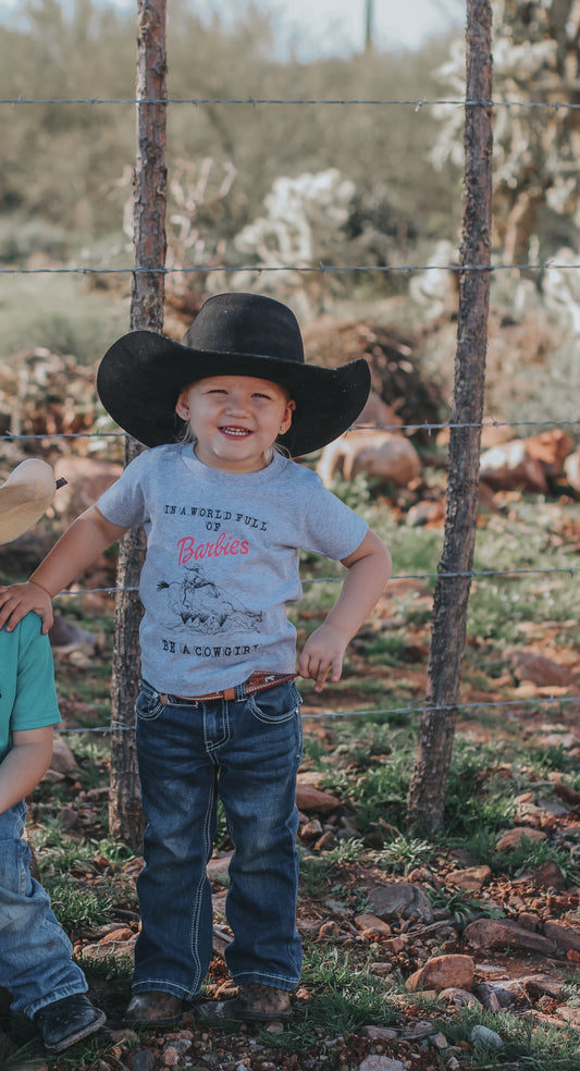 “In A World Full of Barbies Be A Cowgirl" Toddler Tee